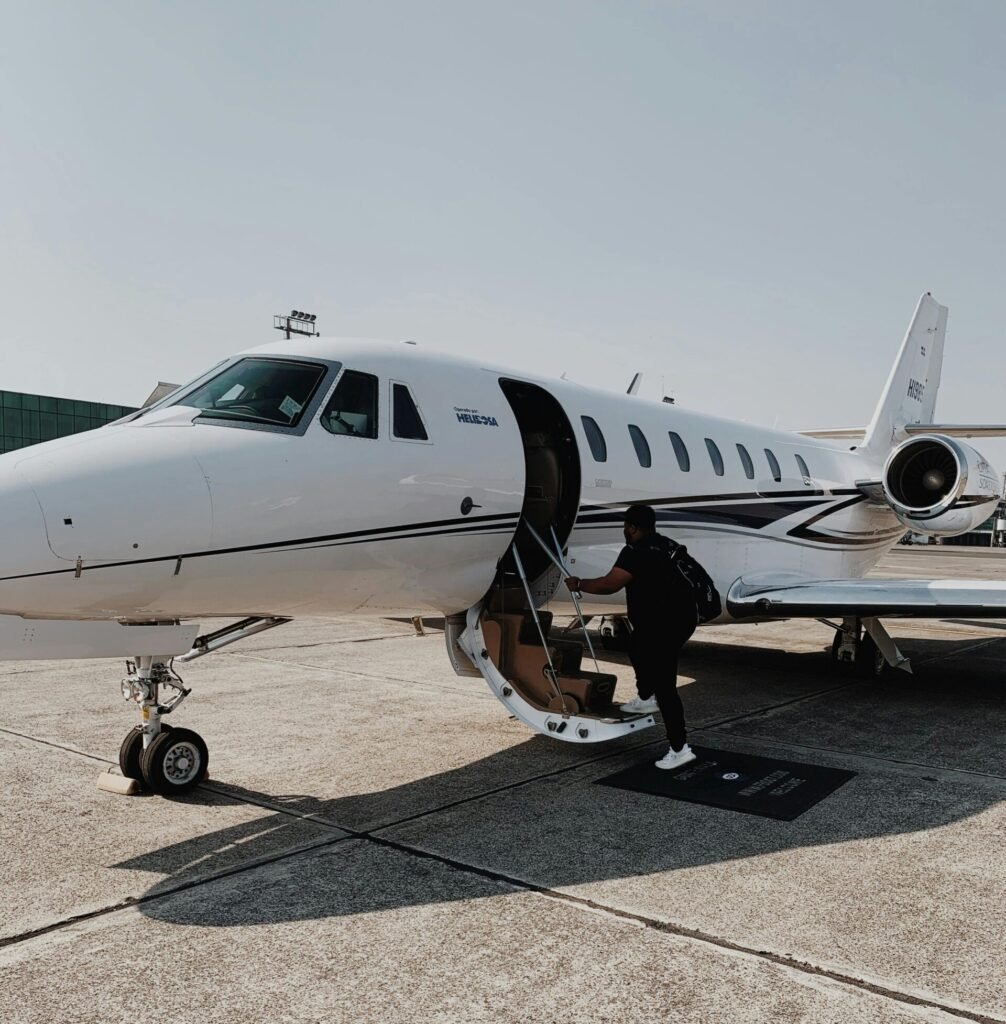 Person boarding a private jet at an airport in Guatemala City on a sunny day.